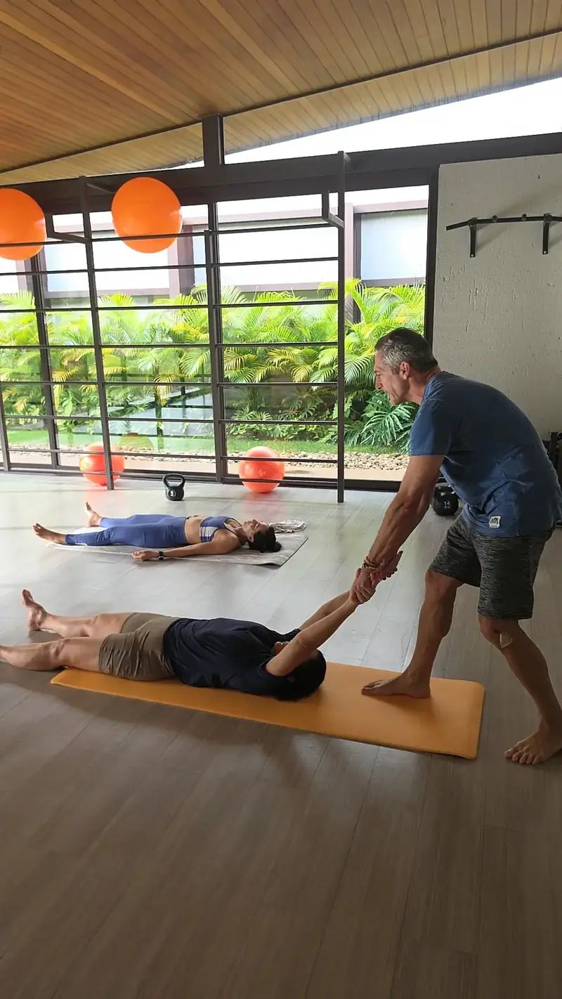 Valeriano Carvalho ajustando aluna em aula de yoga em Uberlândia